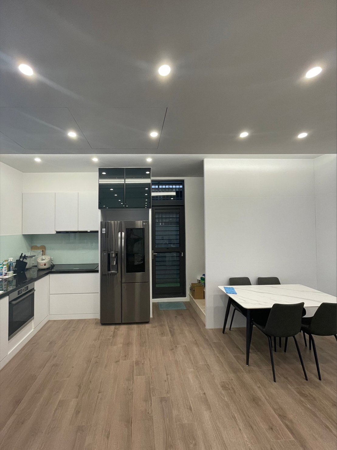 理木曠間餐廚,近景中的餐廚牆面、櫃體與家具配置